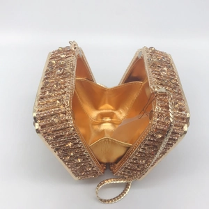 Detailed view of champagne rhinestone dinner clutch with gold chain and mirror lining