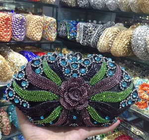 Detail of floral rhinestones on evening clutch showing purple roses and green leaves