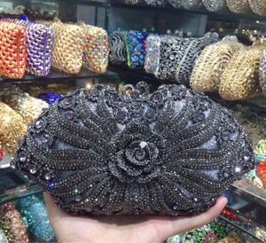 Detail of grey evening clutch with sparkling rhinestones and a large 3D metal rose flower
