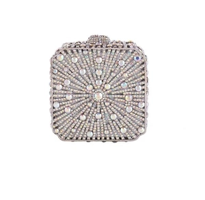 Macro shot of radial AB rhinestones and diamond-encrusted spherical metal clasp on evening bag