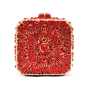 Detailed view of red rhinestone evening bag with sunburst pattern and gold metal frame
