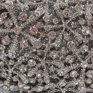 Macro detail of silver starfish evening clutch featuring hollow metal and crystal rhinestones