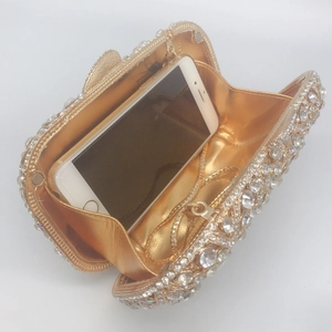 Detailed view of hollow rhinestone evening clutch showing interior space for a smartphone