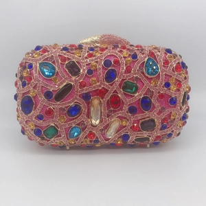 Close-up of luxury metal evening clutch with colorful rhinestones and gold frame details