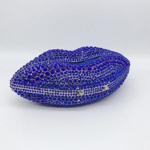 Detailed close-up of a lip-shaped clutch bag with deep blue rhinestones and silver frame