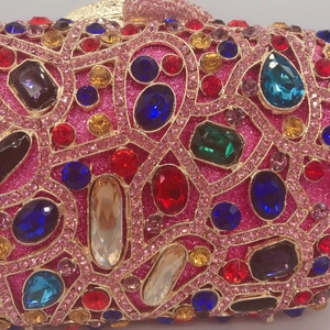 Close-up of luxury evening bag featuring intricate multi-colored rhinestones and pink crystals