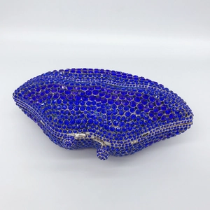 Macro shot of luxury navy blue rhinestone evening clutch with silver metal frame and clasp