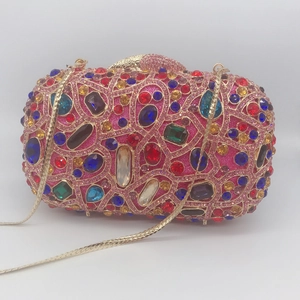 Macro detail of multicolored rhinestone evening clutch bag with gold metal frame and chain