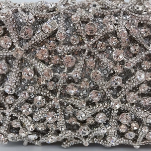 Close-up of sparkling crystals on hollow-out silver starfish evening clutch bag detail