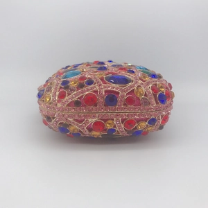 Detailed close-up of luxury evening clutch with colorful rhinestones and gold metal frame
