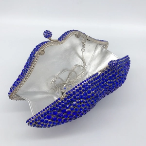Detailed interior of blue rhinestone clutch showing silver lining and metal chain