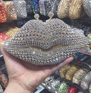 Detailed close-up of a lip-shaped evening clutch with sparkling rhinestones and gold frame