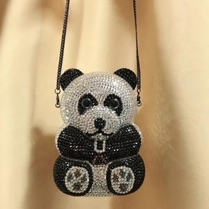 Detail shot of a handmade panda-shaped evening clutch bag with sparkling black and white crystals