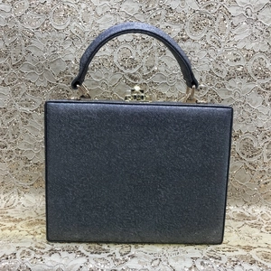 Detail of dark grey Saffiano faux leather handbag with elegant gold twist-lock closure