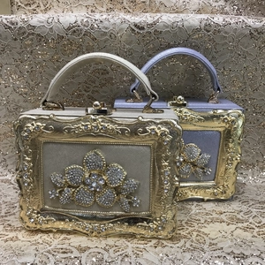 Detail view of crystal floral embellishments on gold and purple evening clutch bags