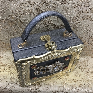 Detail of the glittering evening bag with luxury rhinestone flower pattern and golden frame
