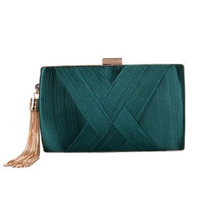 Detailed view of dark green pleated silk clutch bag with gold tassel and metal frame