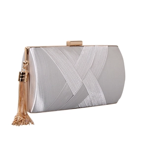 Detailed view of silver satin evening clutch featuring pleated design and gold tassel detail