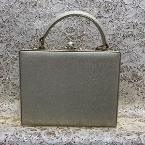 Detailed shot of champagne gold square evening clutch with metallic cross pattern