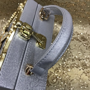 Detailed close-up of sparkling evening bag with golden clasp and rhinestone trim
