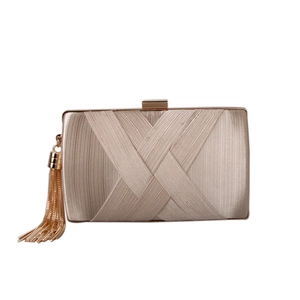 Detail of champagne gold pleated satin evening clutch with elegant metal chain tassels