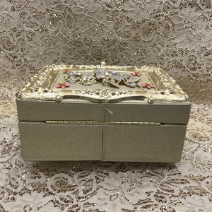 Close-up of champagne gold jewelry box with rhinestones and floral metal relief