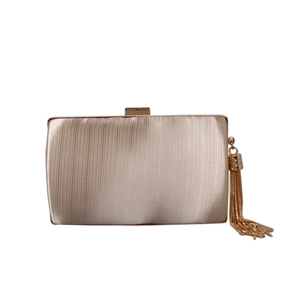 Close-up of champagne pleated satin evening bag featuring gold fringe chain tassel