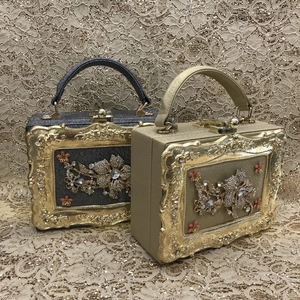 Detail of luxury rhinestone evening bags in black and champagne gold with floral frames