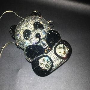 Detailed top view of a handmade panda evening bag covered in black and white crystals