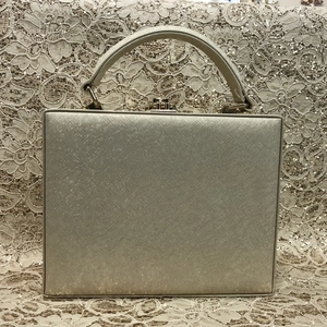 Detail of champagne gold evening bag showing cross-grain texture and metal clasp