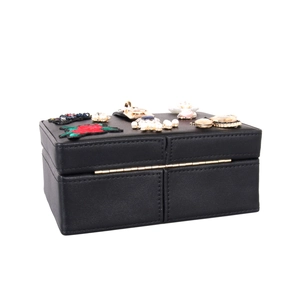 Détail du sac en cuir noir avec broderie florale et décorations de perles et pierres