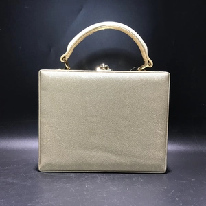 Close-up of golden Saffiano PU leather evening bag with metallic handle and clasp