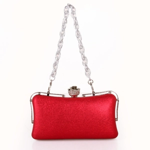 Detail of red metallic evening clutch with floral diamond clasp and silver chain