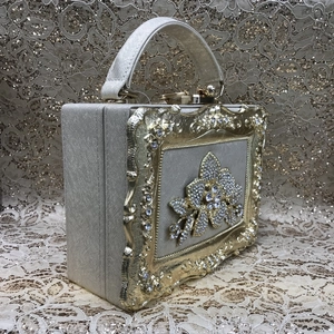 Detail of the champagne gold box clutch featuring an intricate crystal flower pattern