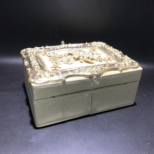 Close-up of golden vintage jewelry box with floral embossing and rhinestone detailing