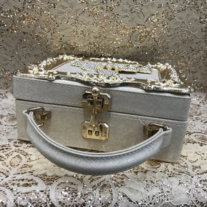 Macro view of champagne gold jewelry box featuring sparkling diamond encrusted top frame