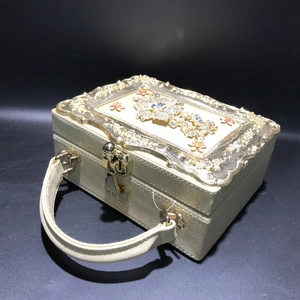 Close-up of golden vintage-style evening bag featuring floral metalwork and sparkling crystals
