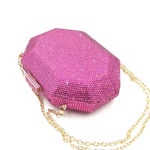 Detail of octagonal clutch with pink crystals, golden frame and chain strap