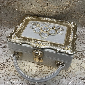 Detailed top view of luxury evening bag with pearl fabric and gold diamond floral frame