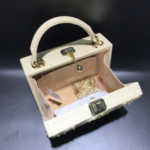 Interior view of champagne gold box bag showing chain strap and phone size reference