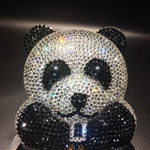 Detailed view of hand-set crystals on a sparkling panda-shaped evening clutch bag