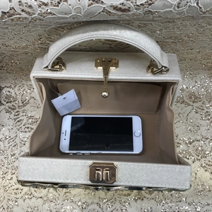 Top view of white Saffiano box bag open interior showing smartphone for scale and capacity