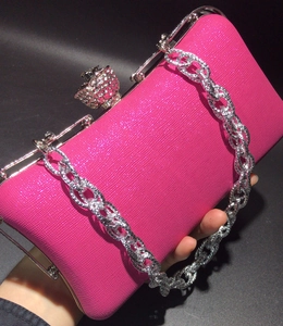 Macro view of rose pink evening clutch with glitter texture and crown crystal clasp
