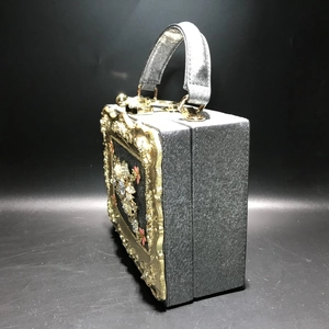 Detail of Baroque box handbag featuring gold floral relief and sparkling crystals