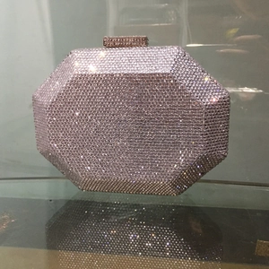 Close-up of luxury octagonal evening clutch bag with sparkling pink rhinestones and crystal clasp
