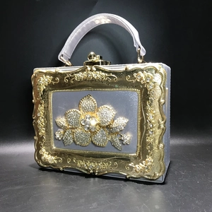 Close-up of vintage box clutch with silver satin finish and rhinestone floral detail