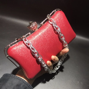 Red textured evening clutch featuring a silver chain and diamond-encrusted skull clasp