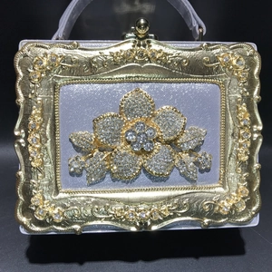 Detail showing vintage silver evening bag with embossed gold frame and crystal flower
