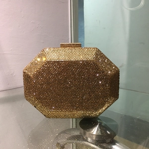 Detail of octagonal gold evening clutch bag with full rhinestone finish and metal clasp