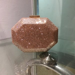 Macro detail of octagonal rose gold evening clutch with sparkling rhinestones and crystal clasp